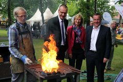 Edzard de Buhr aus Jever schmiedet ein Kreuz, aufmerksam beobachtet von Bischof Thomas Adomeit, Oberlandeskirchenrätin Andrea Radtke und Innenminister Boris Pistorius. Foto: ELKiO/ D.-M. Grötzsch