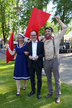 Ein Arbeiter (Jarno Stiddien) und eine Matrosin (Elke Henken) ziehen wie vor 100 Jahren über das Kirchengelände und laden auf die Kirchenmeile ein. Kultusminister Grant Hendrik Tonne ließ sich mitnehmen auf den spontanen Zeitsprung in die Welt vor 100 