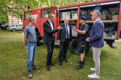 Am Feuerwehrfahrzeug "Möve" der evangelischen Jugend Wesermarsch informiert sich der niedersächsische Finanzminister Reinhold Hilbers über die Arbeit der Evangelischen Jugend Oldenburg. Foto: Jens Schulze